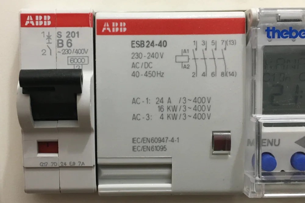 Contactor de instalație montat pe șină, lângă un întreruptor automat și un ceas programator